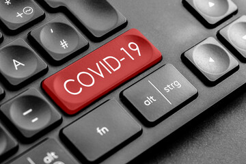 rote Covid 19 Taste auf einer dunklen Tastatur