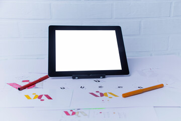 Creative workplace of a Graphic Designer with Tablet. Development of a logo for the company. Drawings and sketches on paper in a art studio office.