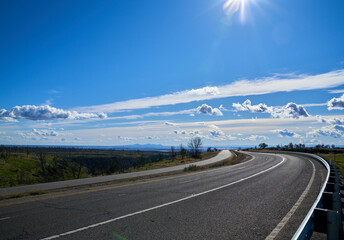 Road in the Mountains with Blue Skies and White Clouds; East view of Skyway Road located in Paradise California. 