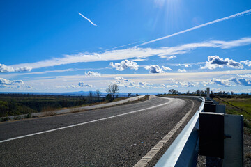 Fototapeta premium Road in the Mountains with Blue Skies and White Clouds; East View of Skyway Road located in Paradise California. 
