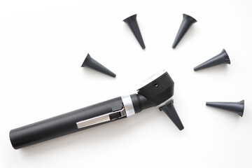 On table is an otoscope with replaceable attachments