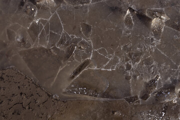 top view of a frozen puddle that is covered with cracks