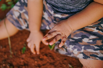 the boy's hand was playing on the dirty ground