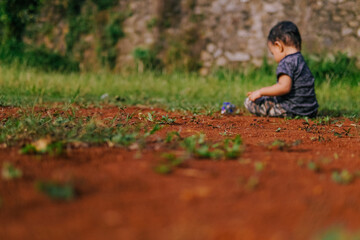 a boy is playing on the dirty ground
