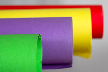 Colorful rolls of paper on a white background, side view