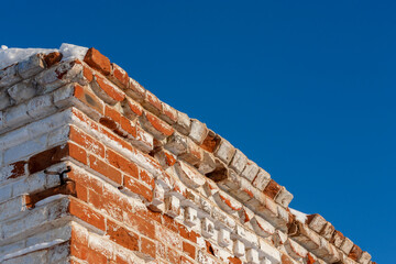 Corner of an old red brick building on a clear winter day. Selective focus.