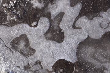 frozen puddle, with white streaks of air under the ice