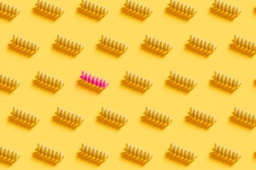 Wholegrain and healthy Italian pasta pattern with pink macaroni on a yellow background. Illuminating color of 2021. Kitchen culinary concept