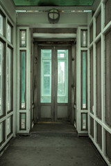 Bright abstract tunnel with elevator door centered with blue and green tones