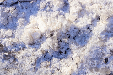 fine snow mixed with ice fragments and stones illuminated by the rays of the sun