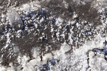 top view of a frozen puddle in which earth and water are mixed