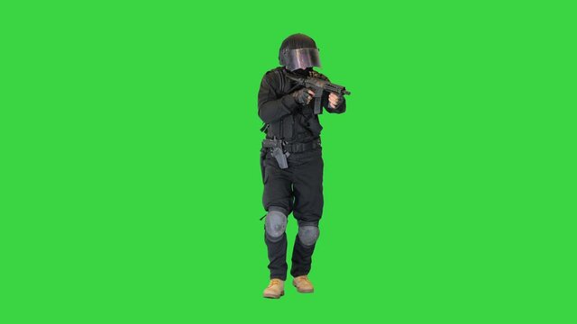 Police anti terrorism squad fighter shooting from rifle on a Green Screen, Chroma Key.