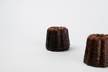 Caneles de bordeaux - traditional French sweet dessert serve with tea or coffee. on white background.