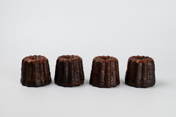 Caneles de bordeaux - traditional French sweet dessert serve with tea or coffee. on white background.
