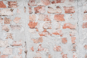 Red brick wall, old surface with peeling plaster. Texture masonry. Vintage background