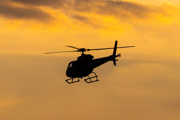 Um helicóptero sob o pôr do Sol.