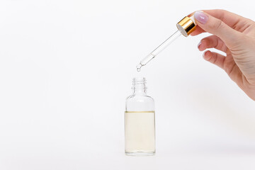 Dropper glass Bottle Mock-Up. Oily drop falls from cosmetic pipette on white background
