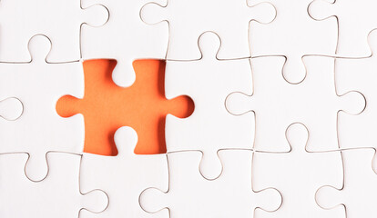Obraz premium Top view flat lay of paper plain white jigsaw puzzle game texture incomplete or missing piece, studio shot on an orange background, quiz calculation concept