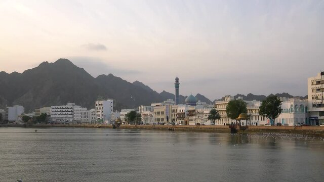 Mutrah corniche during sunrise with seagulls flying and calm weather. Muscat, Oman