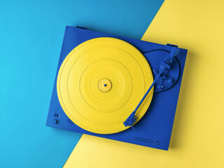 Stylish yellow and blue vinyl record player on a yellow and blue background.