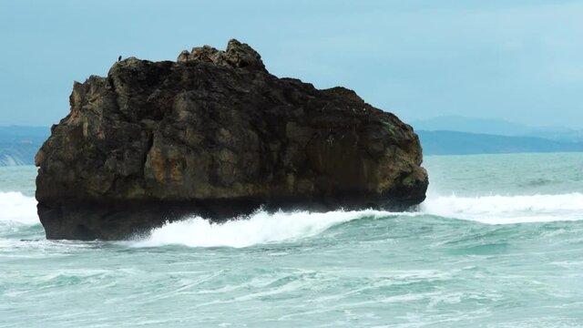 Large rock in the sea with breaking waves crashing into it. Filmed at 50fps and slowed to 50% real time.

Locations in France Biaritz beach.
