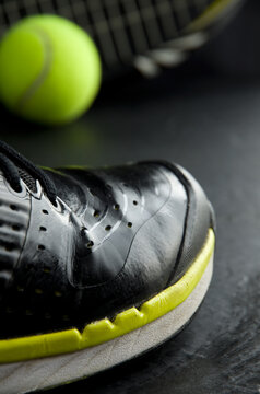 Black & Yellow Tennis Shoe With Tennis Ball And Racquet In Background