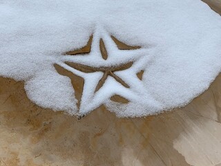 Star in rock with snow outlining it