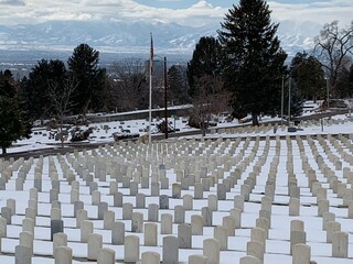 Cemetery in the winter snow with white military headstones perfectly aligned
