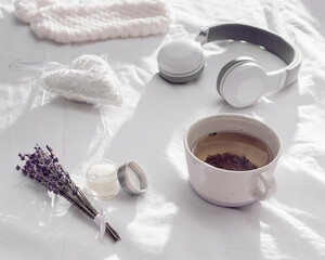Flat lay with healthy herbal lavender tea in cup for relaxation before bedtime. Sleep mask and balsam with essential oil