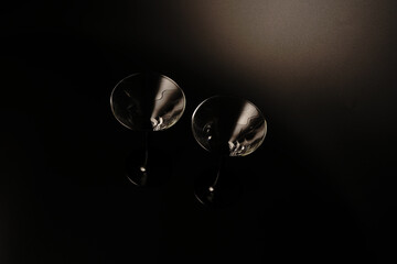 Two empty cocktail glasses on a black background. Studio shooting.