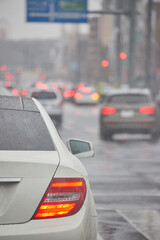雨の日の車のフロントガラスから見た通勤の町風景