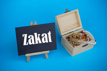 ZAKAT word coin stacked, rice grain in bowl and mini house on blue background. Muslim concept for zakat property, income and "fitrah" zakat.