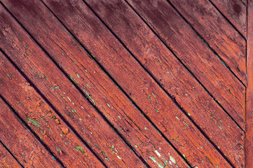 Vintage textured background. Old wooden board made broken planks stacked diagonally, faded red...