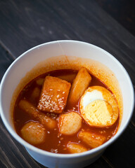 Stir-fried Rice Cake Tteok-bokki in a takeaway container. Korean food delivery.