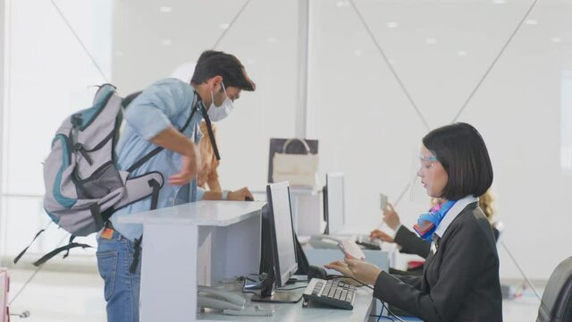 Caucasian male passenger handing passport to airline staff to check-in