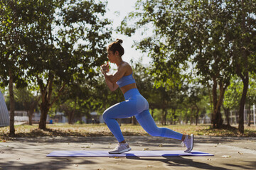 Asian woman Healthy She exercises outdoors, she does leg lunge poses.