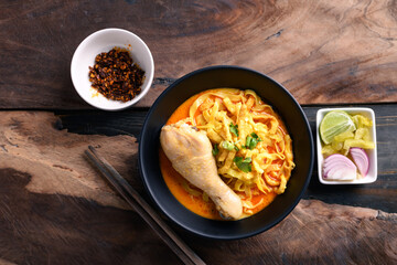 Northern Thai food (Khao Soi), Spicy curry noodles soup with chicken eating with crispy deep-fried egg noodles, pickled mustard, shallots, lime and ground chilies in oil