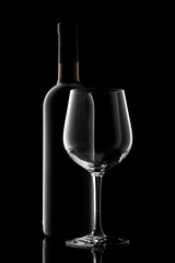 red wine bottle and wine glass isolated on black background