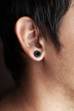 ear piercing,guy with a black tunnel in his ear