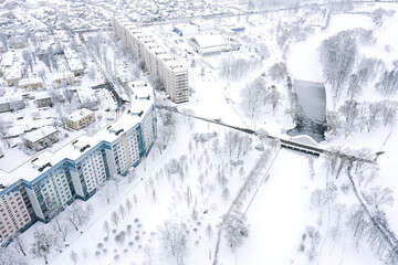 aerial panoramic view of residential district covered by snow in winter time, located near city park