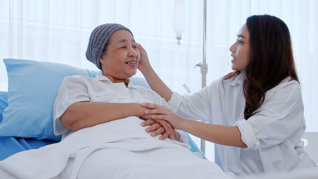 daughter encourages and comforts a mother with cancer during hospitalization.