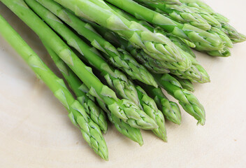 Fresh green asparagus on cutting board.
