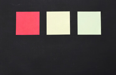 Blank colorful note paper on black chalkboard.