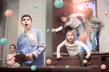 Surprised tween boy solving conundrums in quest room with friends. Toned image with visual 3d effect