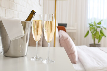 Bottle and glasses of champagne on table in hotel honeymoon room