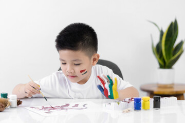 Happy little kid at the table draw with watercolor Learning and education of kid.