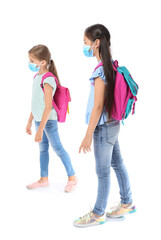Fototapeta premium Little schoolchildren in medical masks on white background. Coronavirus epidemic