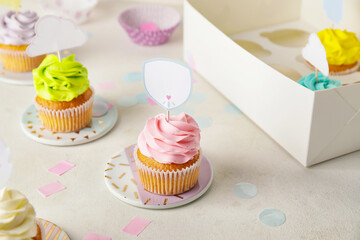 Tasty cupcakes with stylish toppers on light background