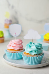 Tasty cupcakes with stylish toppers on light background