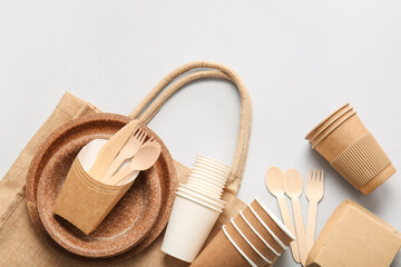Eco tableware and bag on light background
